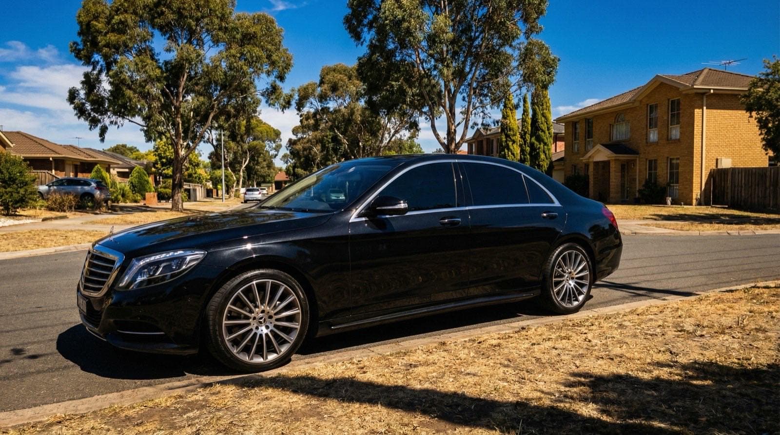 Black sedan with dark legal-limit window tint on an Australian street showing NSW tint law compliance