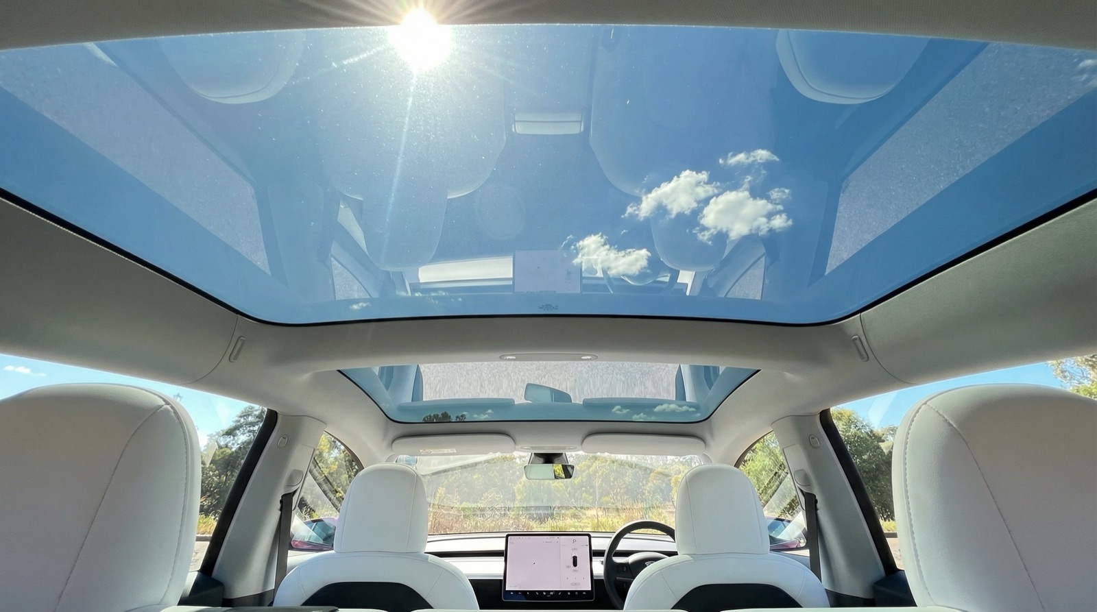 Interior view of Tesla Model 3 glass roof panel showing expansive untinted glass before ceramic tint